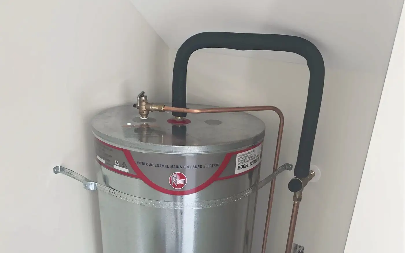 Top of a mains pressure hot water cylinder, showing the relief valve and its copper drain line