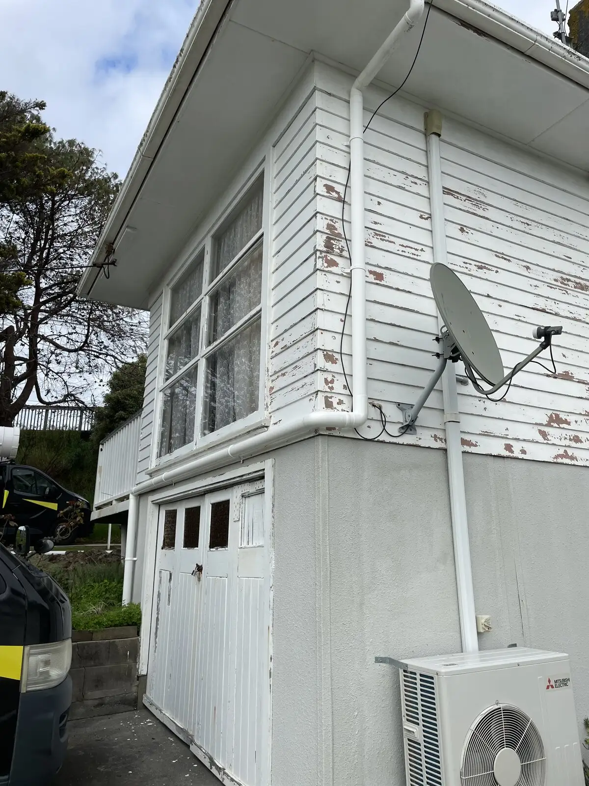 Downpipe on a white weatherboard North Shore home