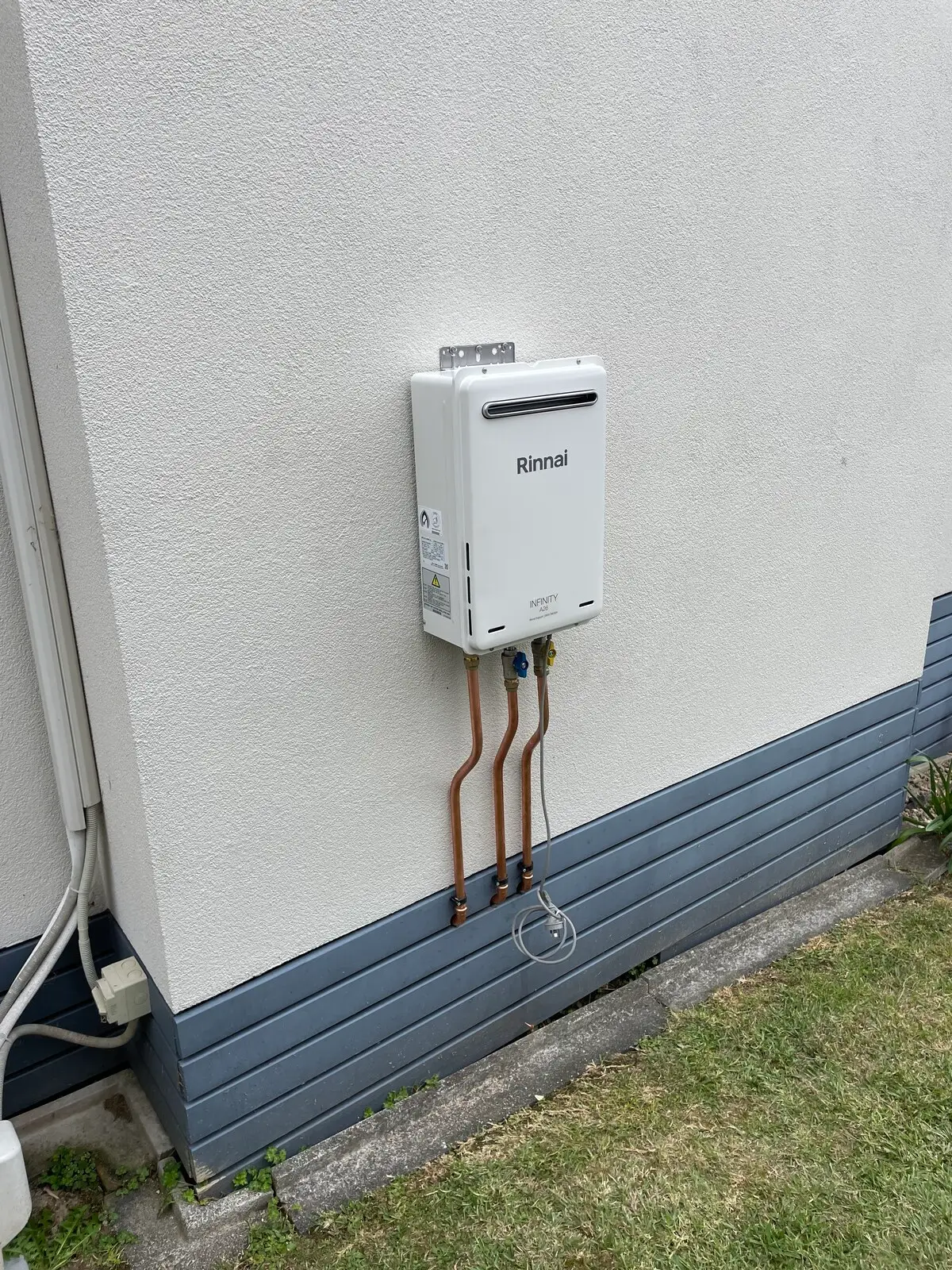 Rinnai continuous flow gas hot water unit on a weatherboard house near Browns Bay