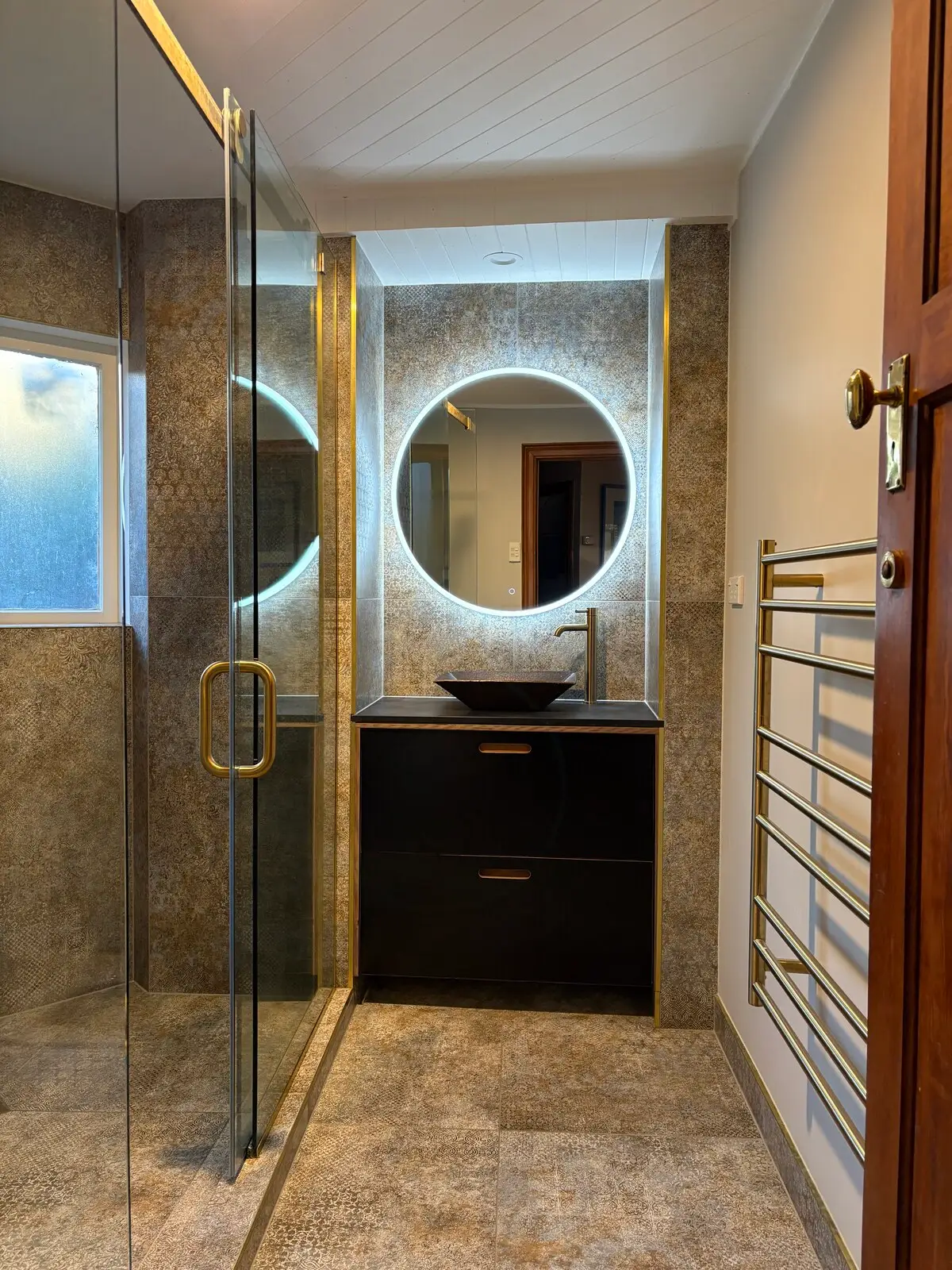Renovated bathroom in Highbury, Birkenhead, with a glass walk-in shower, gold tapware, an LED mirror and a dark vanity