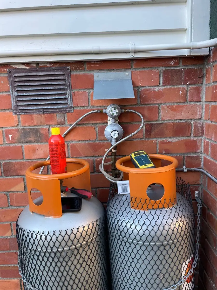 LPG bottles and regulator installed on a brick wall