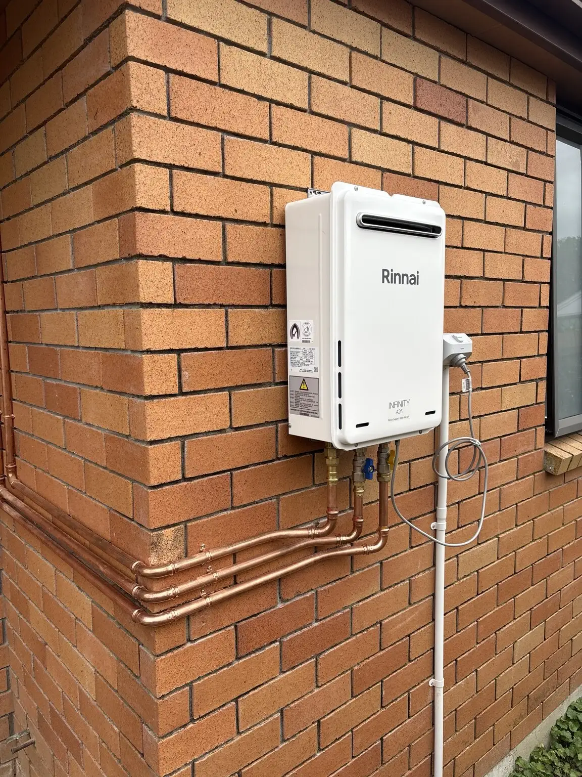 Rinnai continuous flow unit on a brick wall
