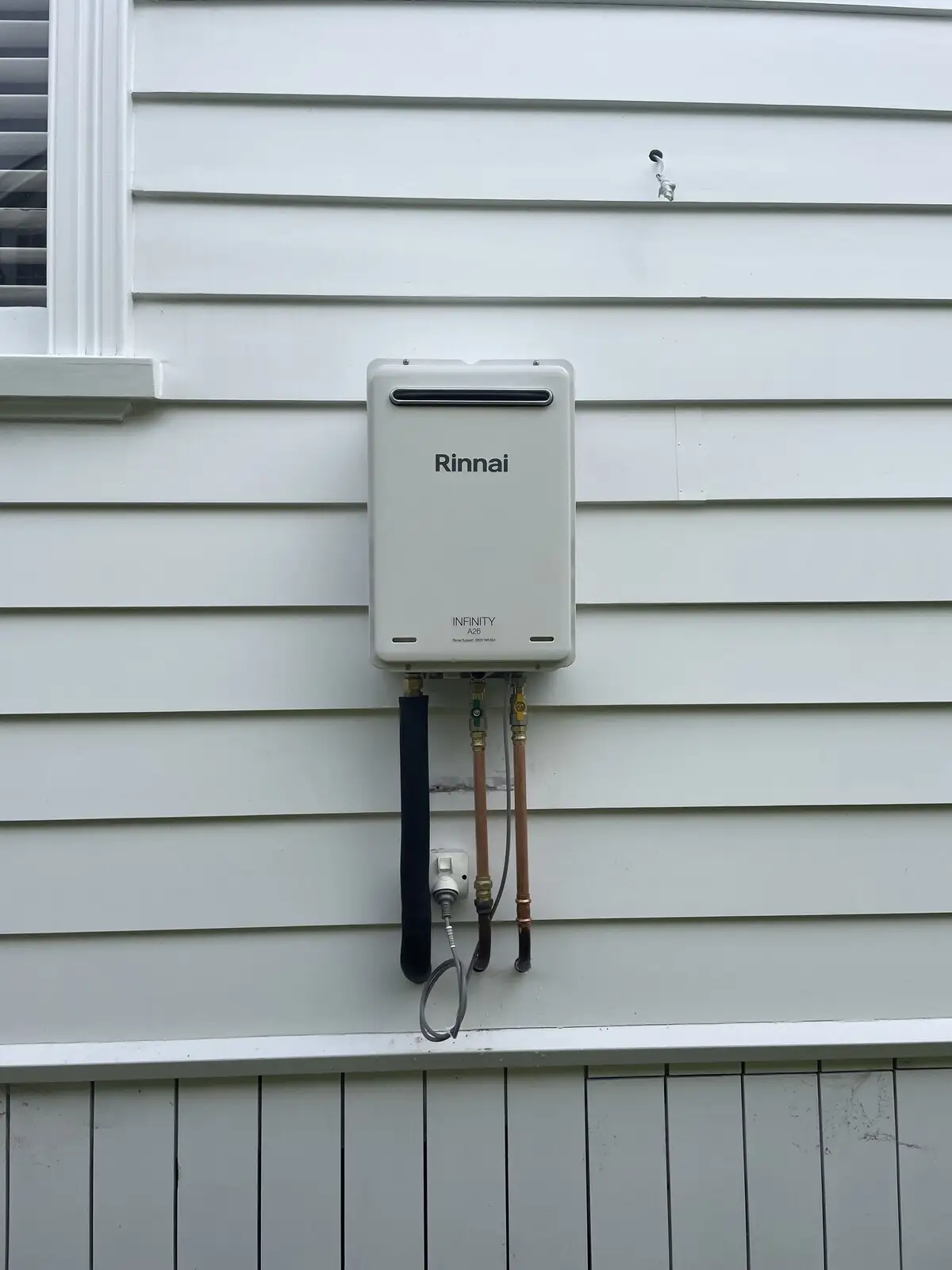 Continuous flow gas unit on a weatherboard wall