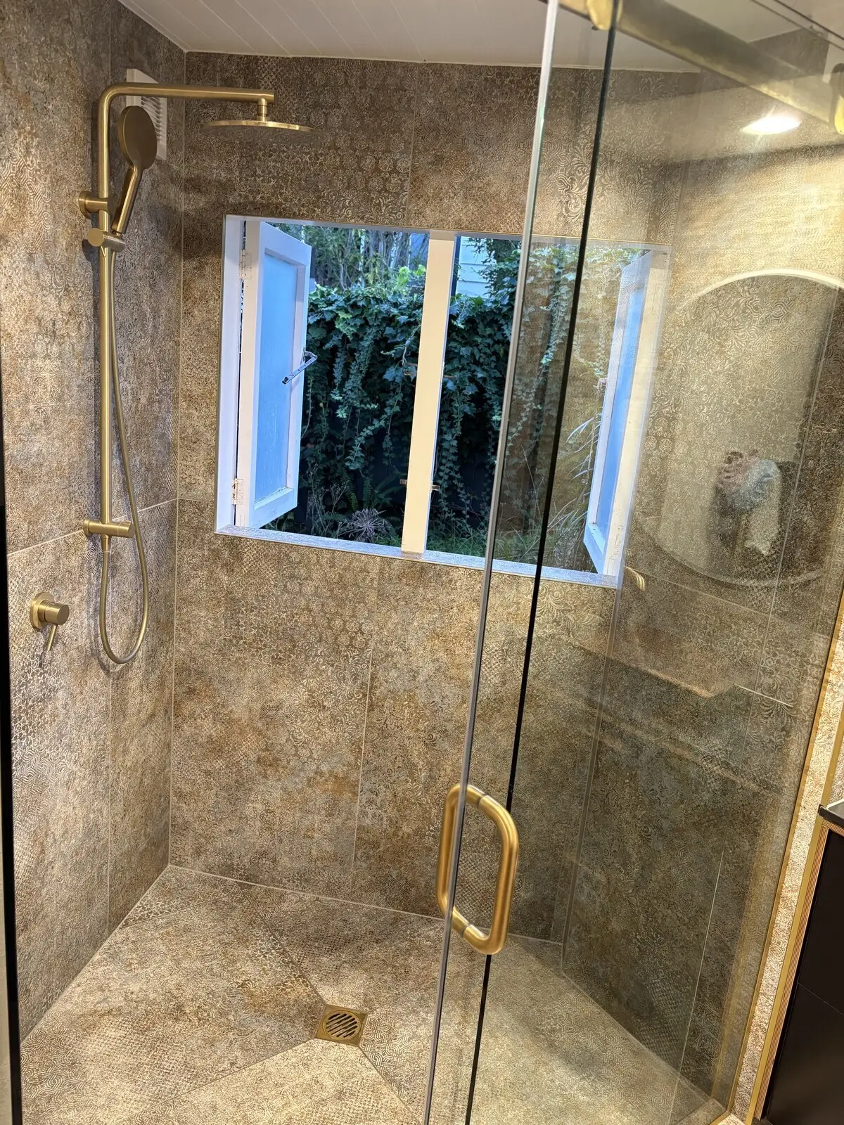 Walk-in tiled shower with brass fittings