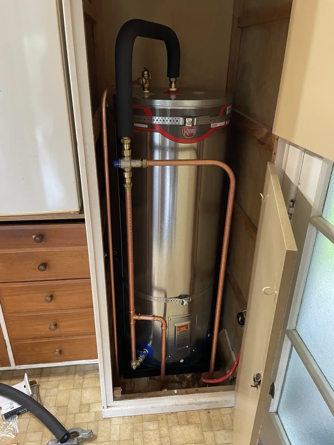 New Rheem hot water cylinder installed in a laundry cupboard
