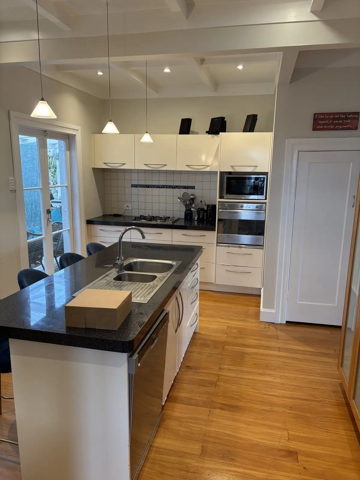 White kitchen with an island bench and timber floor