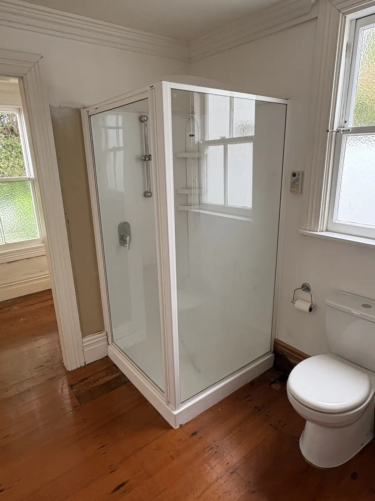 Simple white shower and toilet after a refresh