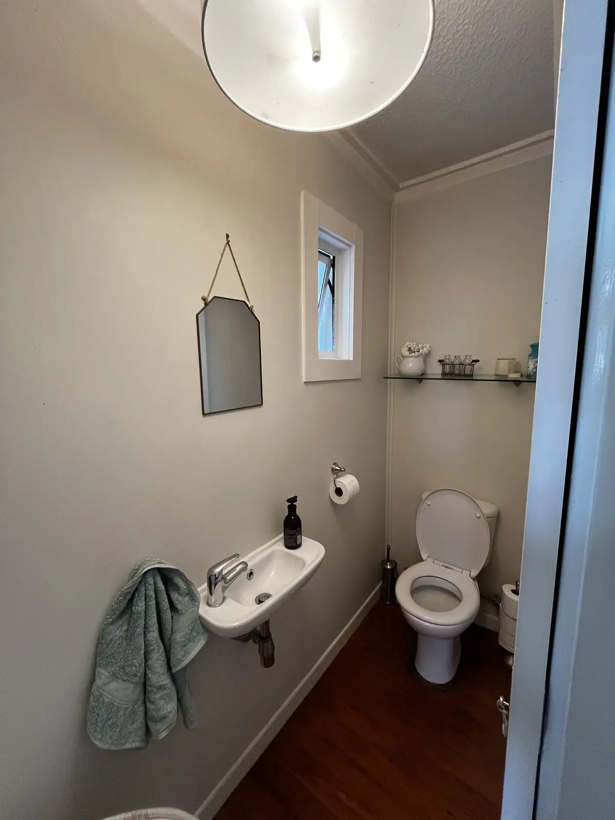 Before: dated powder room with an old basin and toilet