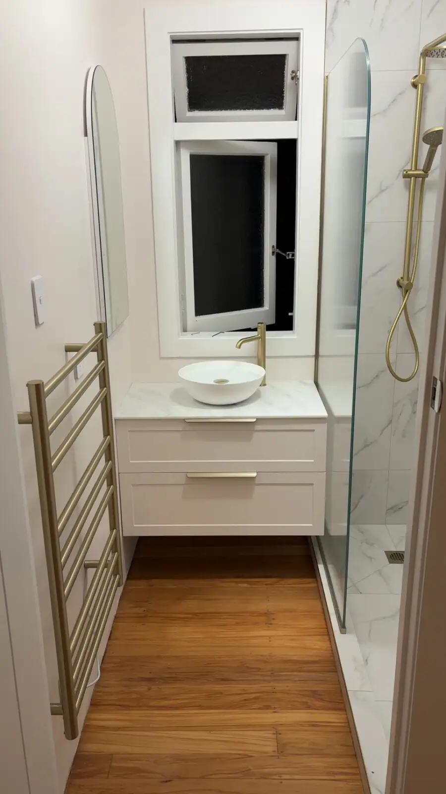 New vanity with brass tapware and glass shower