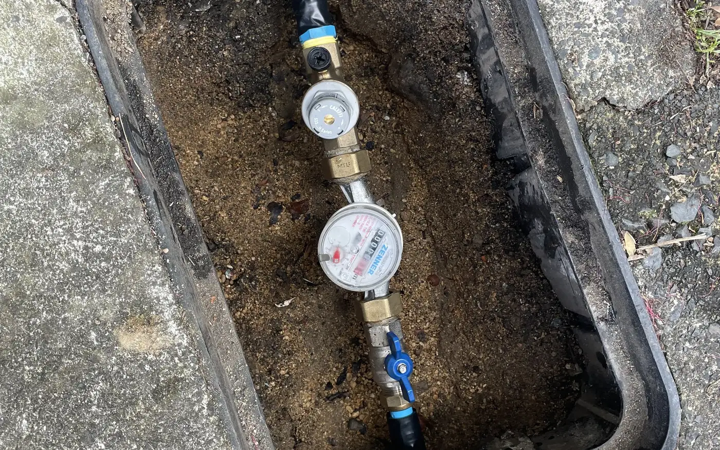 An Auckland water meter box opened up, showing the meter and the valve on the property side